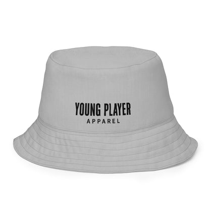 Young Player Apparel grey reversible bucket hat with minimalist black logo branding for streetwear style.